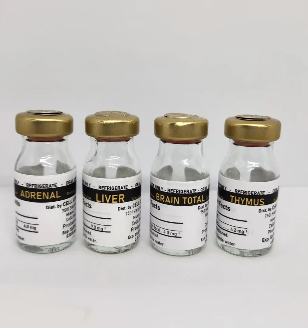 Four small glass vials with gold caps, labelled Adrenal, Liver, Brain Total and Thymus, stand in a row on a white surface